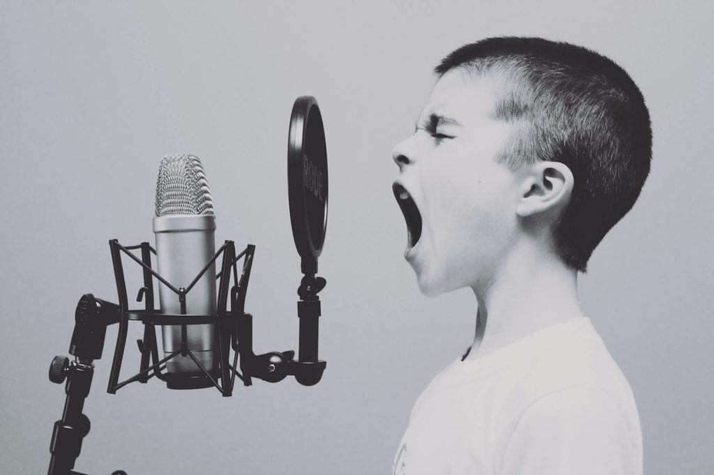 young boy yelling into microphone and he wants to be heard by everyone driving more traffic to his site