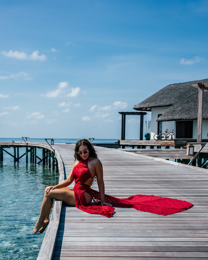 Isabella in a red dress on a pier 