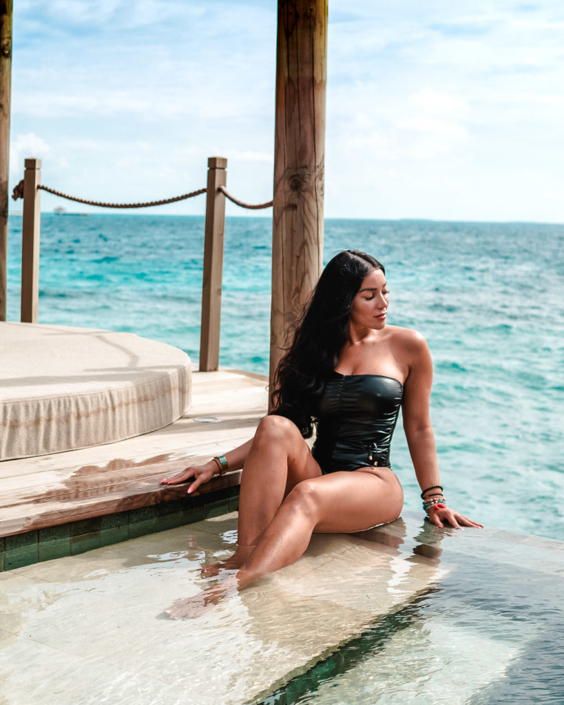 Isabella in a black swimsuit at a Maldives luxury travel resort