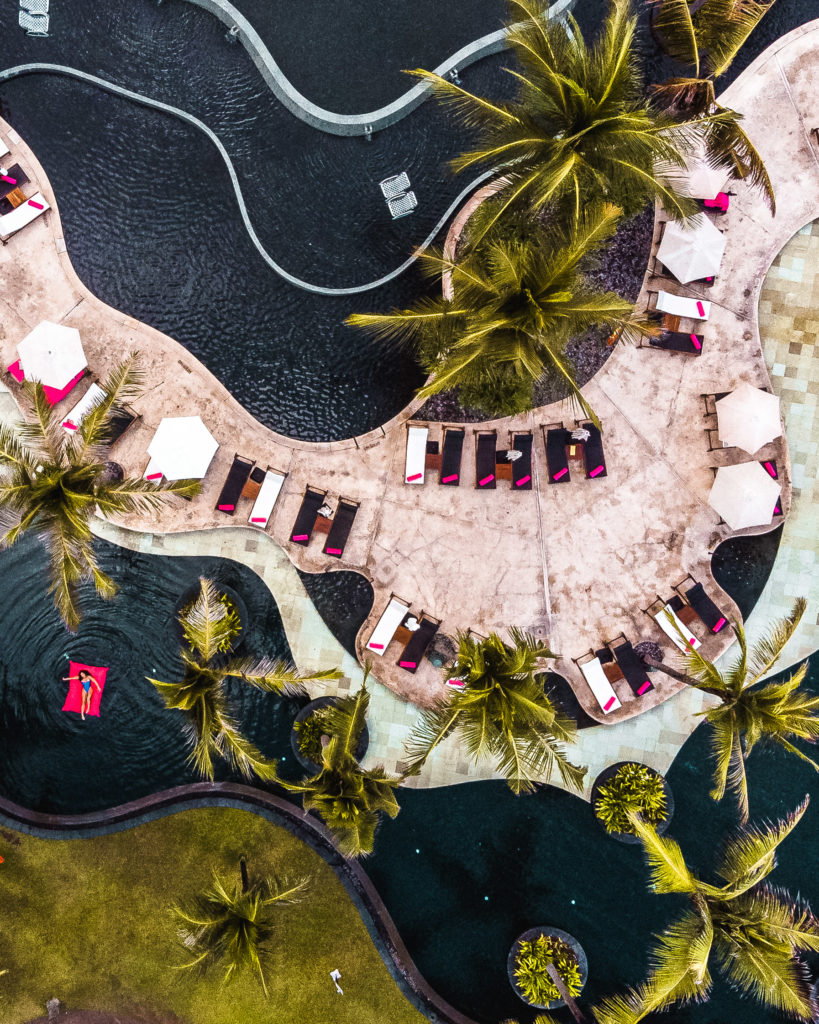 drone shot the pool of the W Hotel in Seminyak, a Bali luxury travel resort 