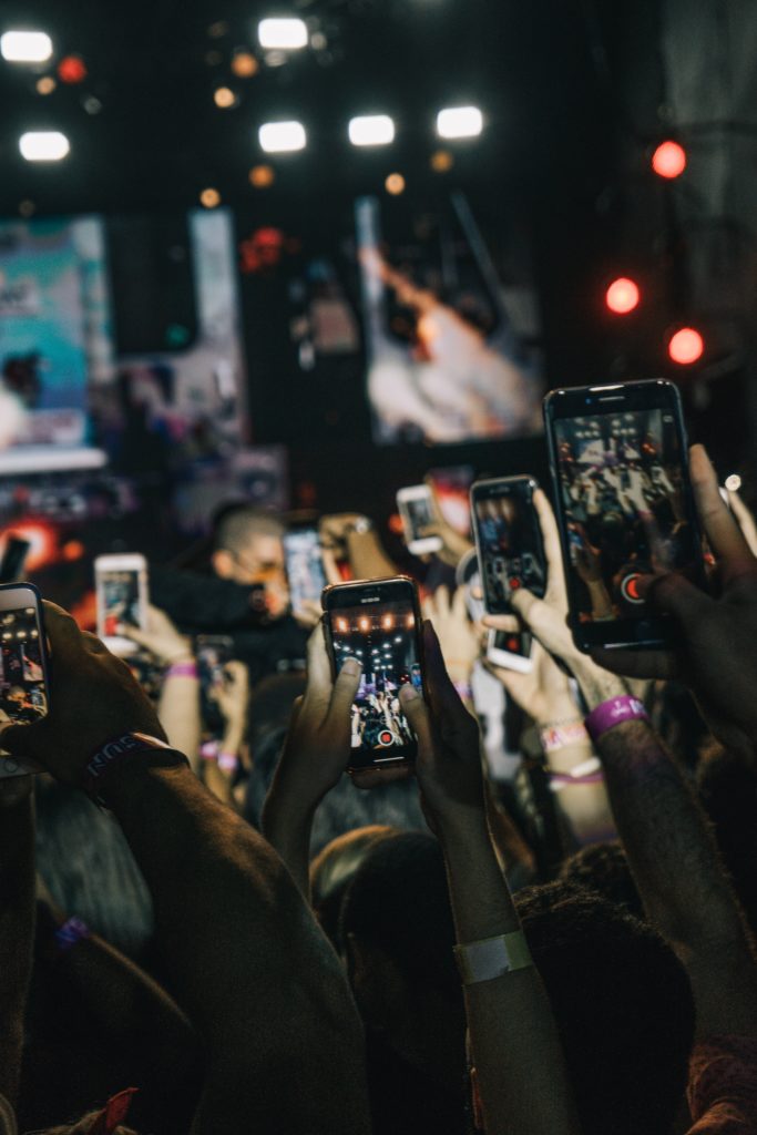 A crowd holding up their phones and recording