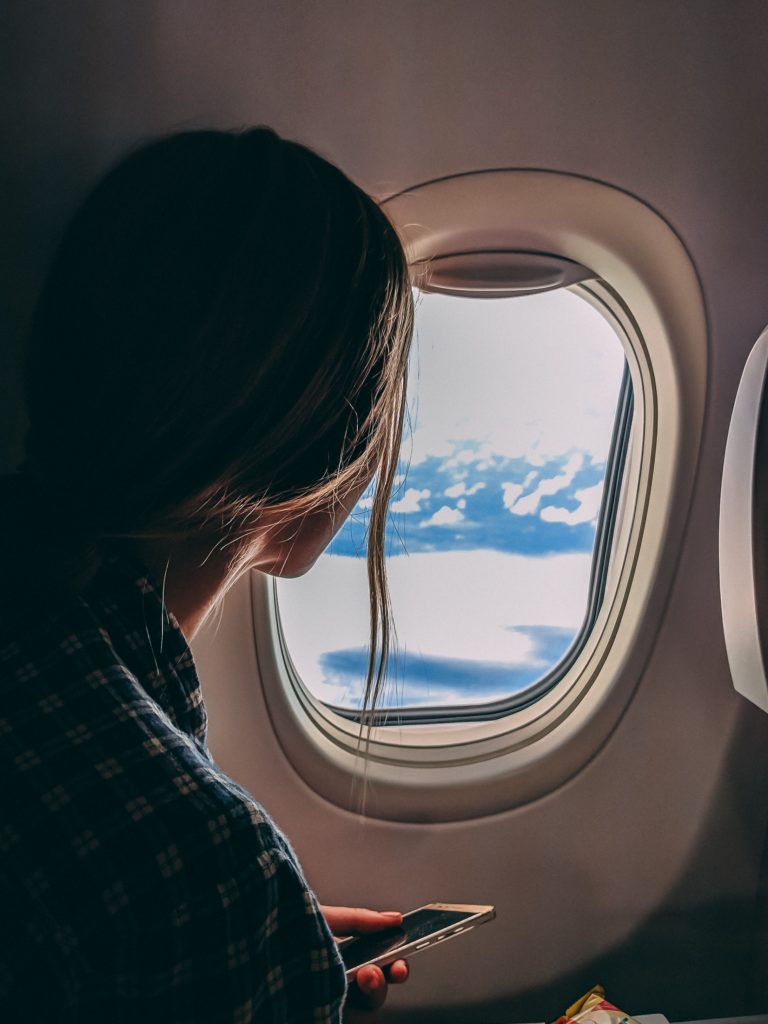 Woman looking out of the window on airplane 
