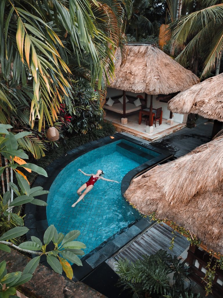 Girl floating in pool at Bali luxury travel resort 