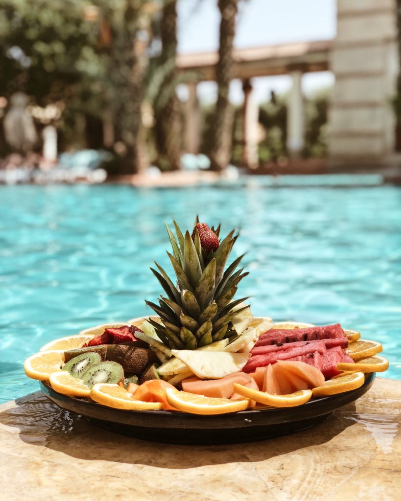 Platter of fruit next to a swimming pool 