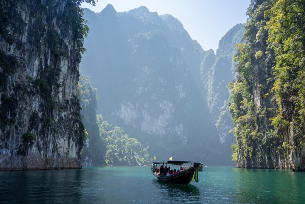 Boat sailing past limestone cliffs in Thailand