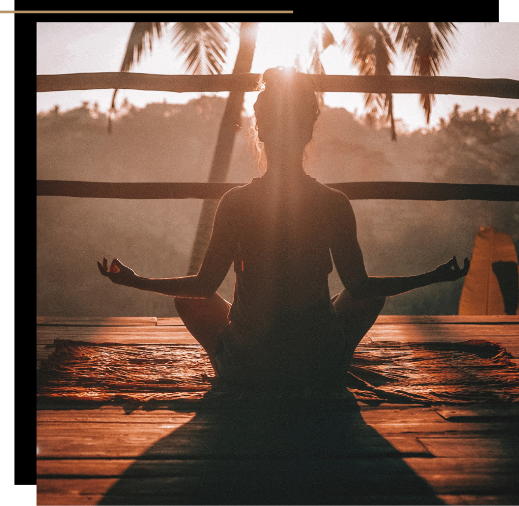 Woman meditating at sunset on a balcony 
