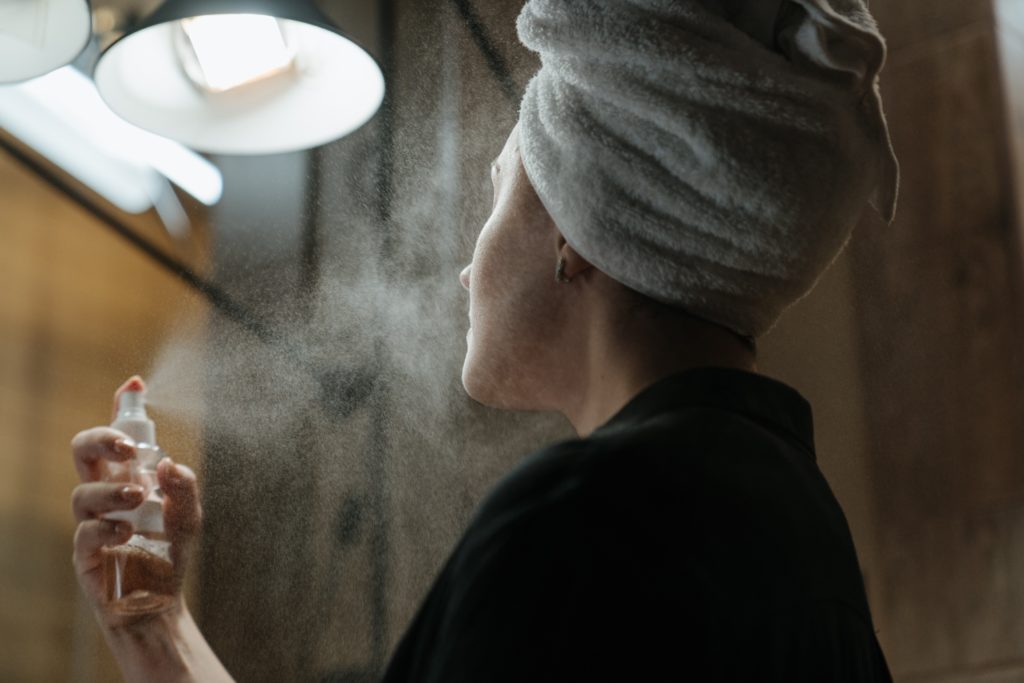 A woman spraying her face 