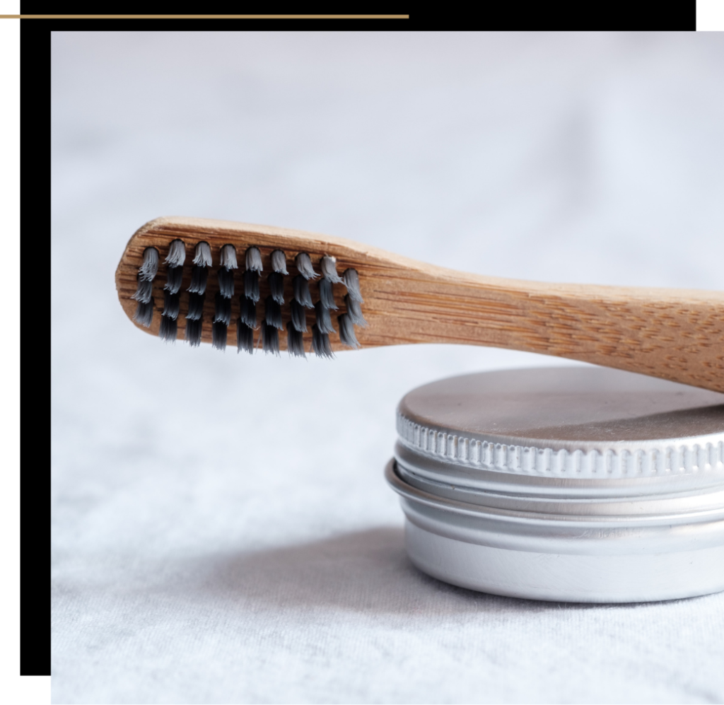 A bamboo toothbrush and container of toothpaste