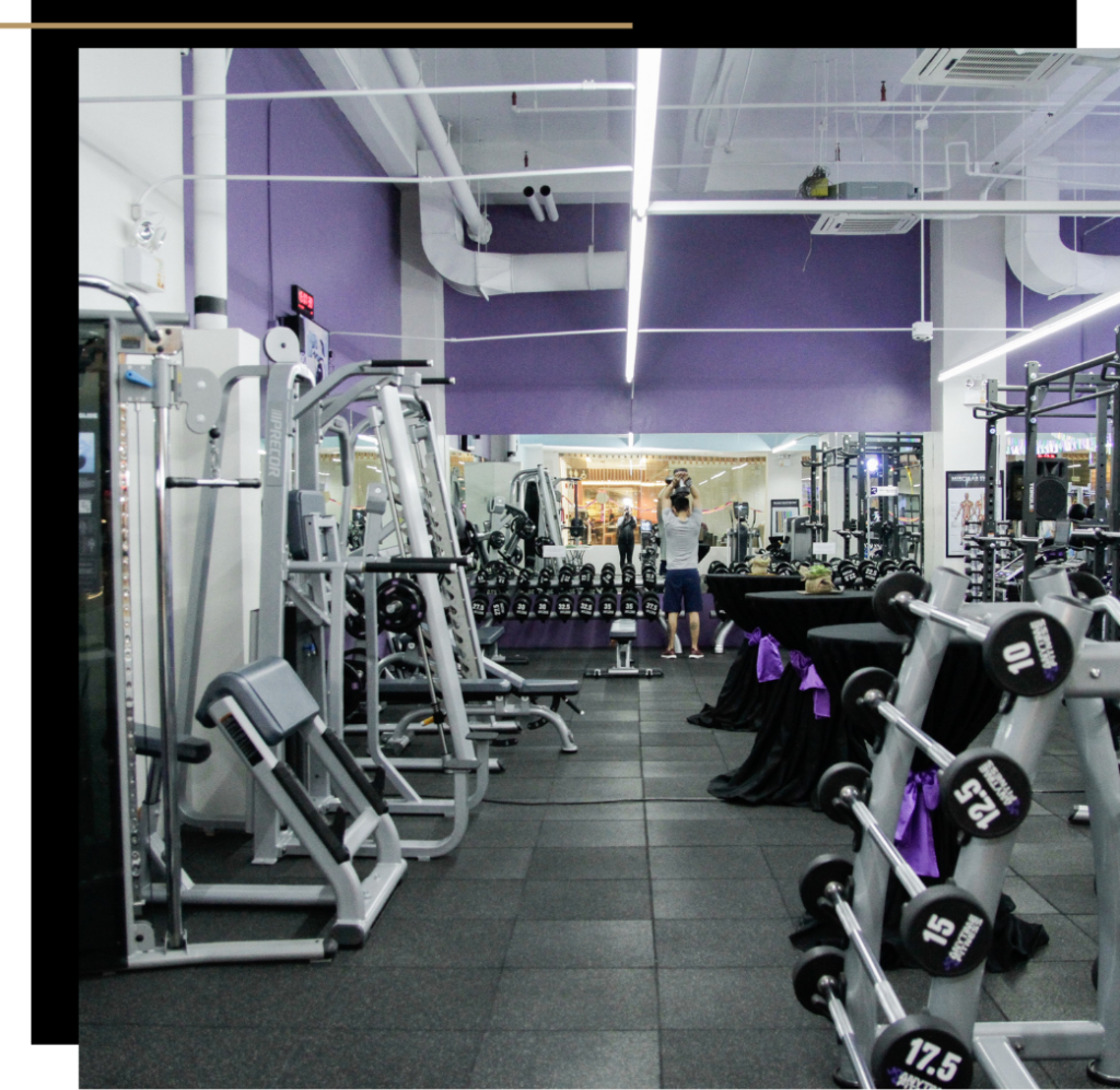 A gym with purple walls and weight lifting equipment 