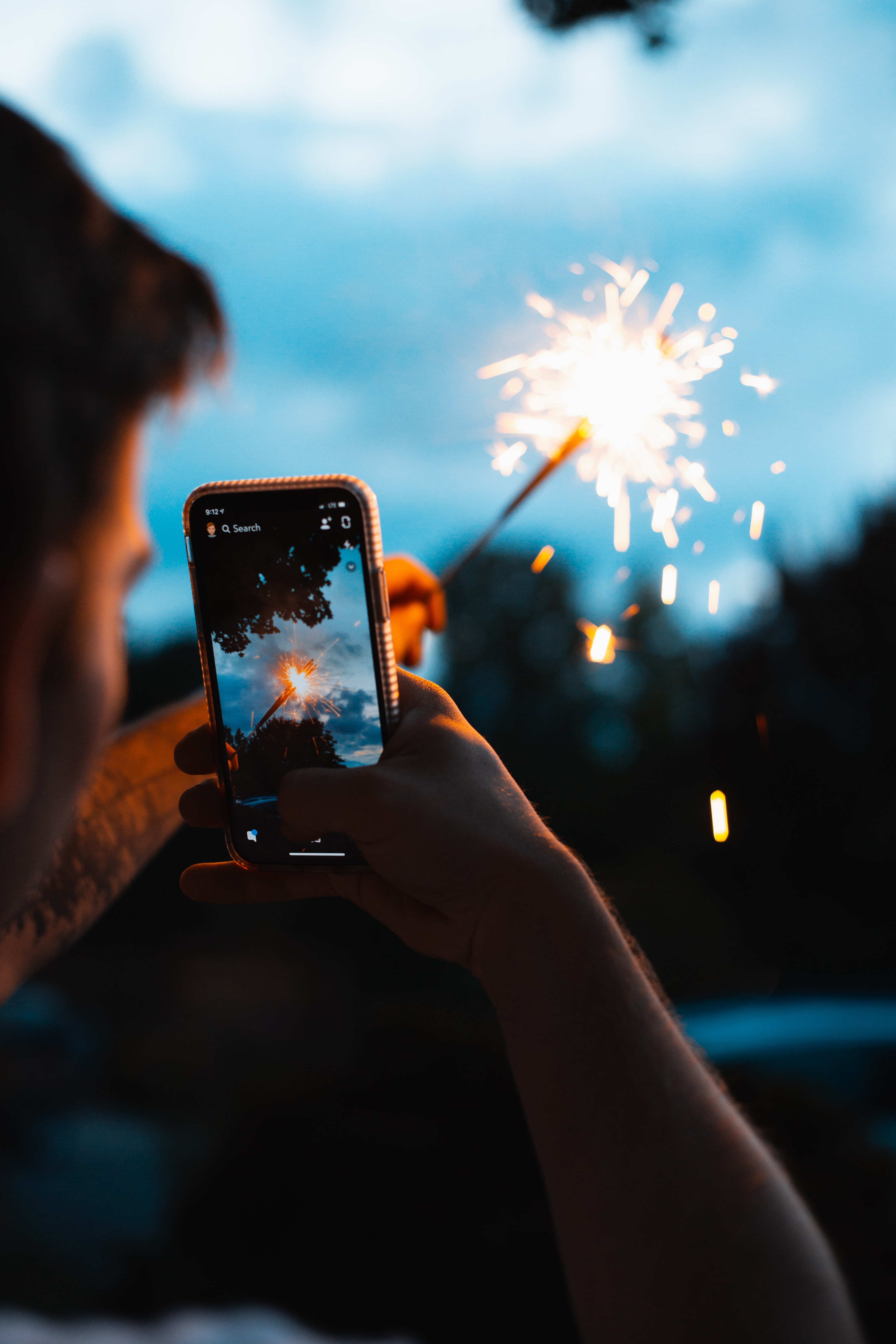 A user taking a snapchat video of a sparkler