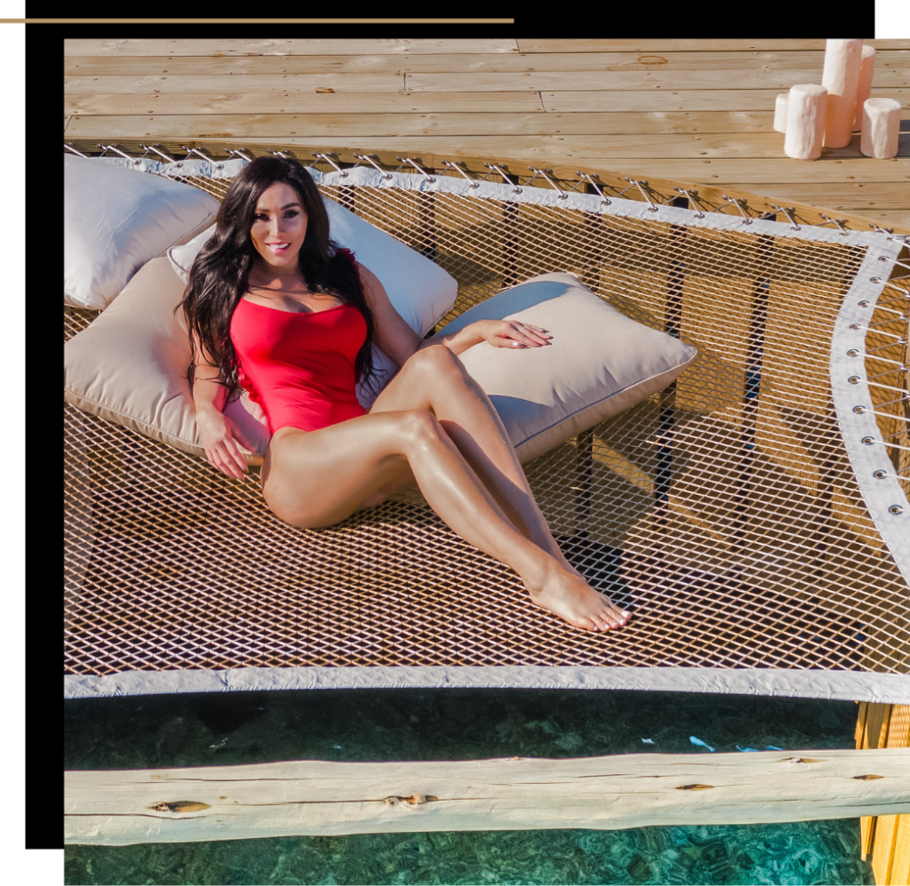 Isabella relaxing on a hammock in a red bathing suit at Soneva Fushi Maldives